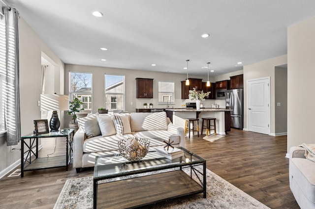 living area featuring dark wood-style floors, visible vents, baseboards, and recessed lighting