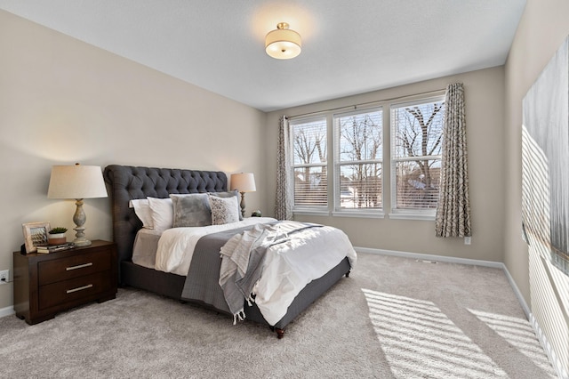 bedroom with baseboards and light colored carpet