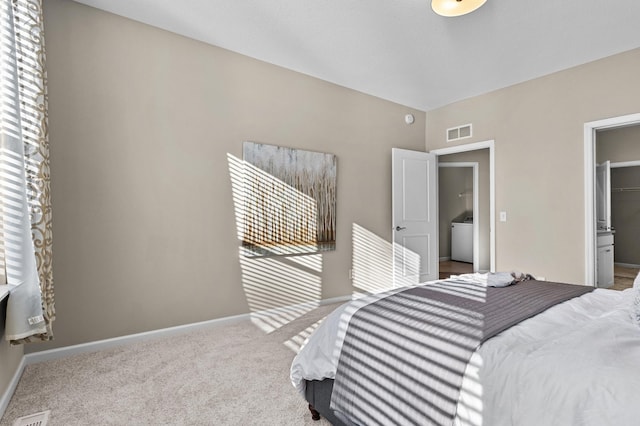 bedroom with carpet floors, washer / dryer, visible vents, and baseboards