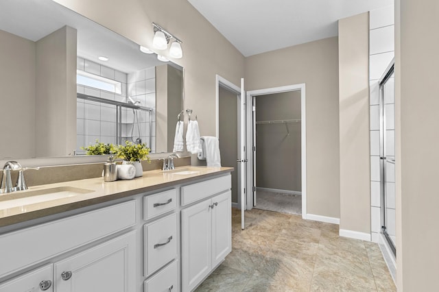 bathroom featuring double vanity, a shower stall, and a sink