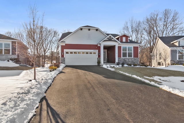 craftsman-style house with driveway, stone siding, and an attached garage