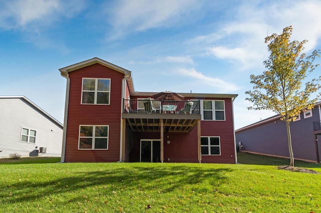 rear view of house featuring a lawn and a wooden deck