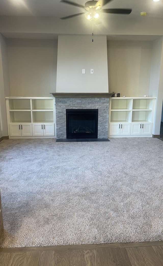 unfurnished living room with a fireplace and ceiling fan