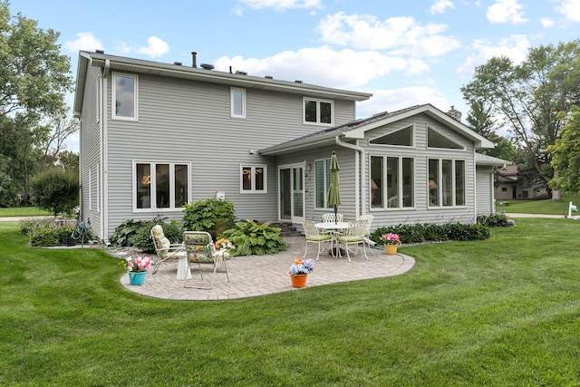 back of property with a patio area and a yard