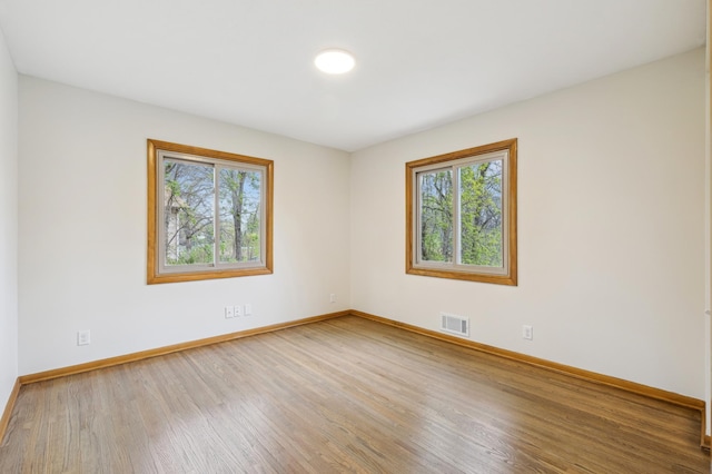 5745 Echo Rd, Excelsior, MN 55331 - spare room with visible vents, baseboards, wood finished floors, and a healthy amount of sunlight