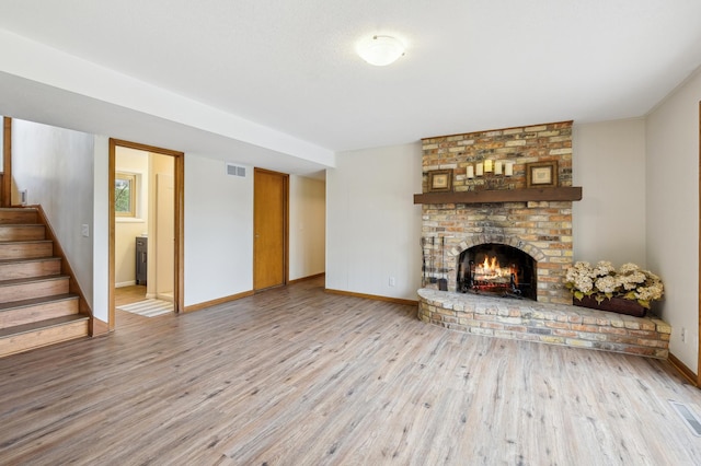 5745 Echo Rd, Excelsior, MN 55331 - unfurnished living room featuring visible vents, a fireplace, wood finished floors, stairway, and baseboards