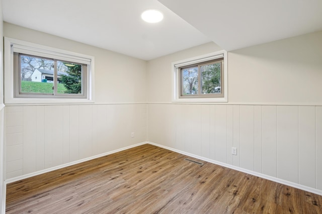 5745 Echo Rd, Excelsior, MN 55331 - empty room featuring baseboards, wainscoting, wood finished floors, and visible vents