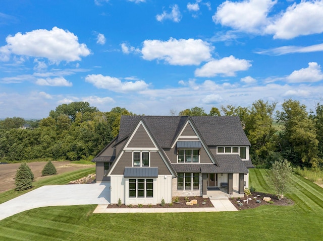 view of front of house featuring roof with shingles and a front lawn