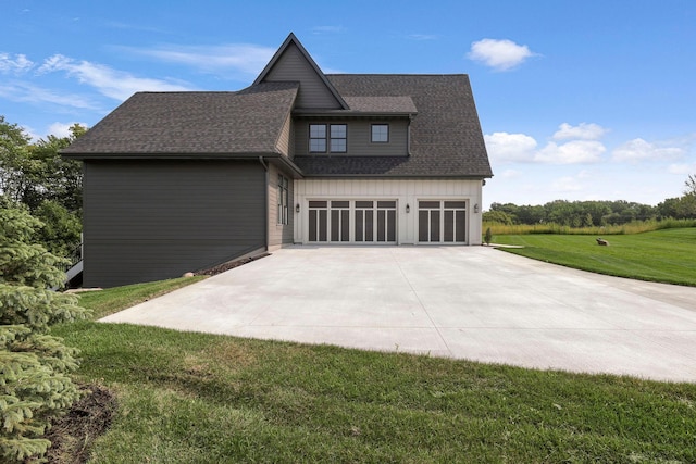 view of home's exterior with a garage, concrete driveway, roof with shingles, a yard, and board and batten siding