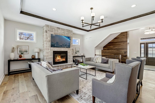 living area with ornamental molding, a fireplace, hardwood / wood-style flooring, and a healthy amount of sunlight