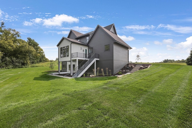 back of house with board and batten siding, stairway, a lawn, and a wooden deck