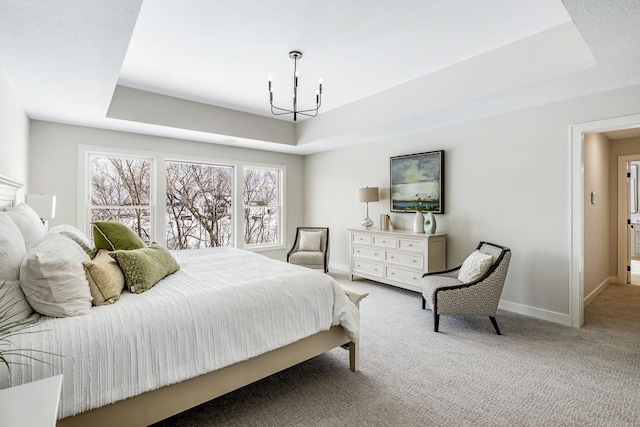 bedroom with carpet, a raised ceiling, and baseboards