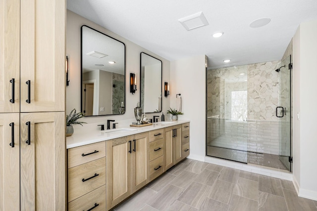 full bath with double vanity, a shower stall, a sink, and recessed lighting