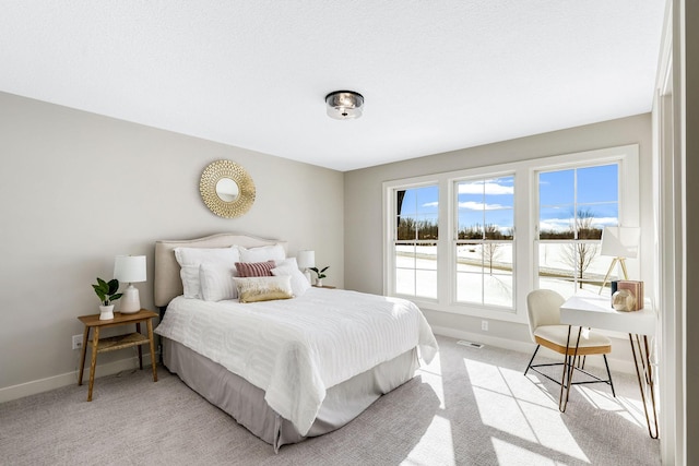 bedroom with light colored carpet and baseboards