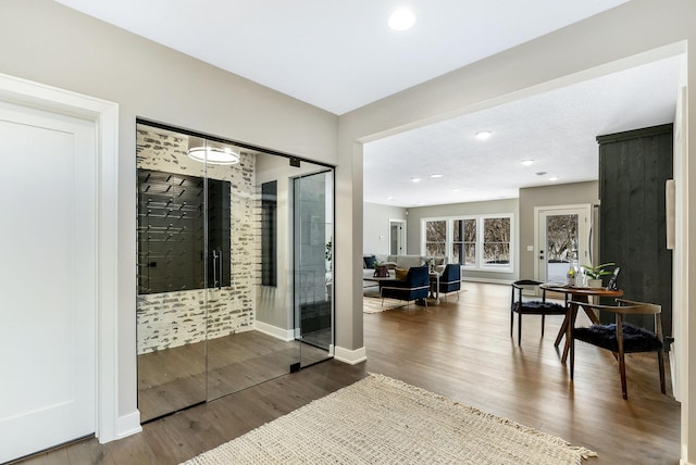 interior space with baseboards, wood finished floors, and recessed lighting