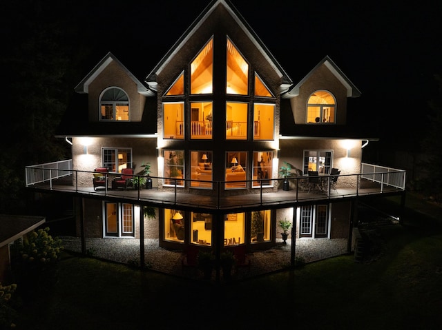 back house at twilight featuring a balcony