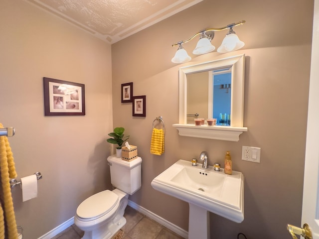 bathroom with a textured ceiling, toilet, and tile patterned flooring