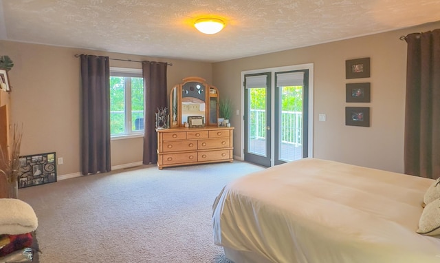 bedroom with multiple windows, carpet, access to outside, and a textured ceiling