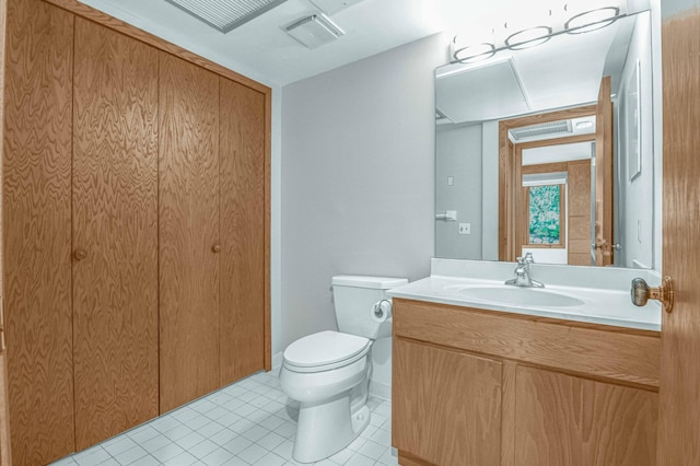 bathroom featuring tile patterned flooring, toilet, and vanity