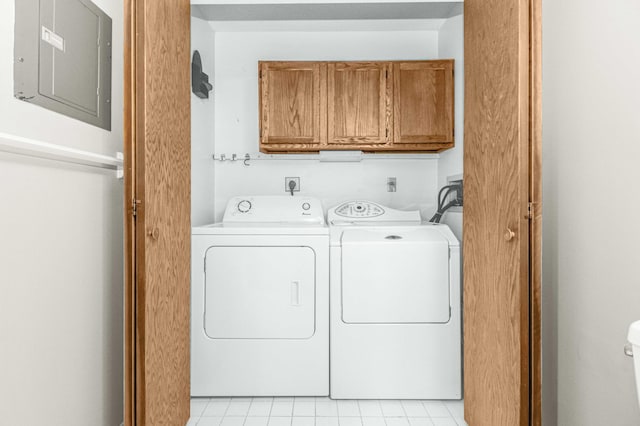 laundry room featuring washing machine and dryer, cabinets, electric panel, and light tile patterned floors