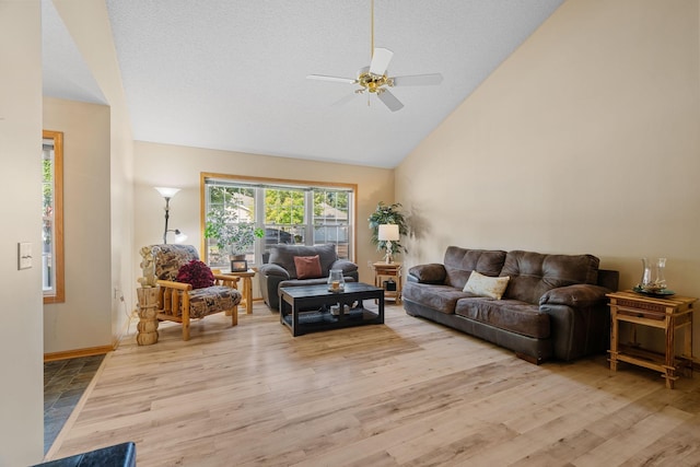 living room with ceiling fan, light wood-type flooring, and high vaulted ceiling