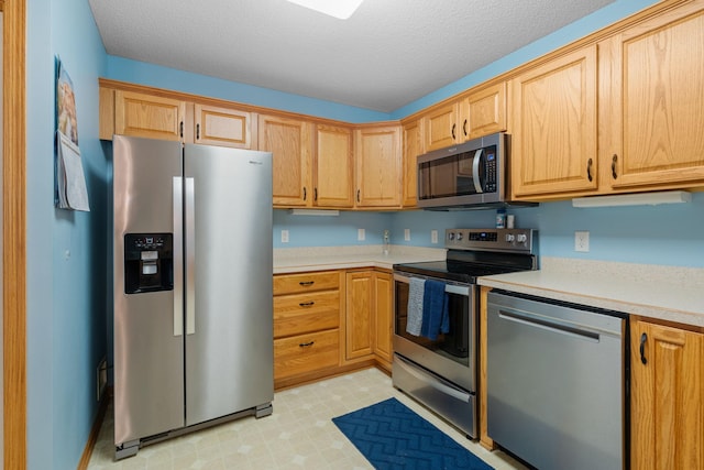 kitchen with appliances with stainless steel finishes and a textured ceiling