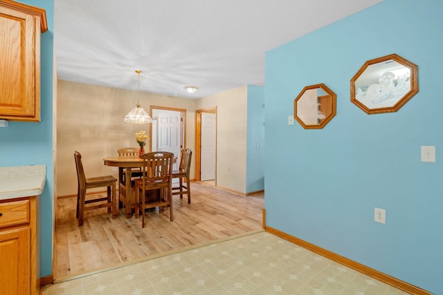 dining space featuring light wood-type flooring and a notable chandelier