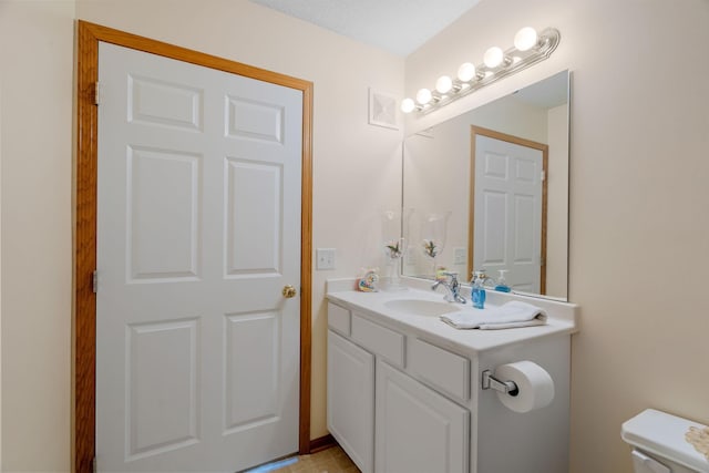 bathroom featuring a textured ceiling, vanity, and toilet