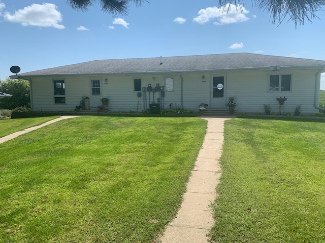 ranch-style home with central air condition unit and a front yard