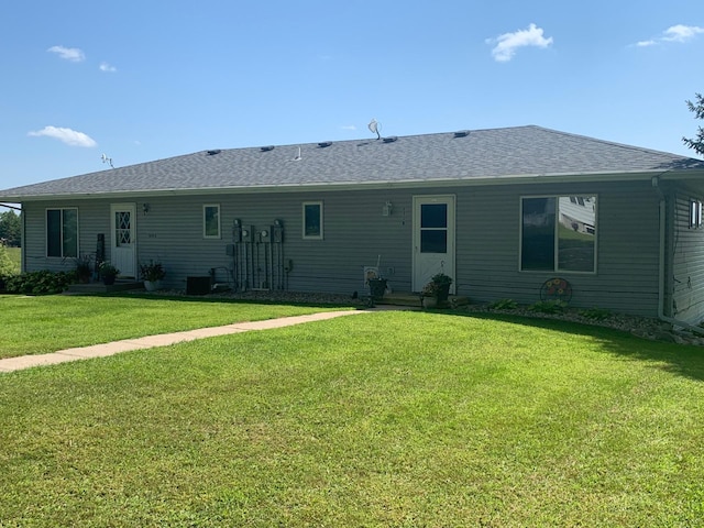 rear view of property featuring a lawn