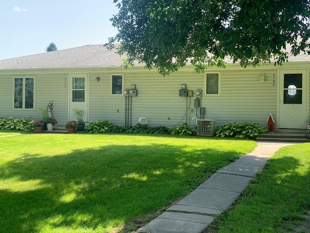 view of front of property featuring central AC unit and a front yard