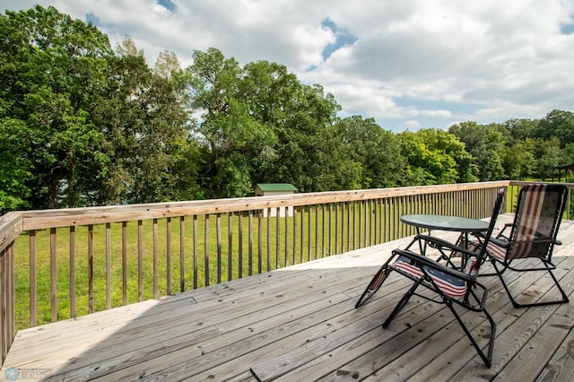 deck featuring a storage shed and a yard