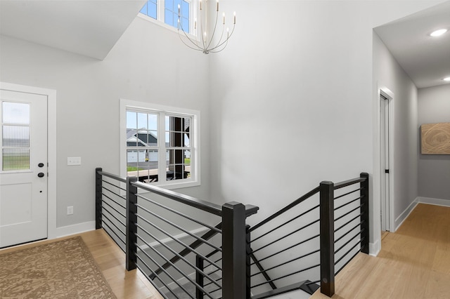 entrance foyer with hardwood / wood-style floors, a wealth of natural light, and a chandelier