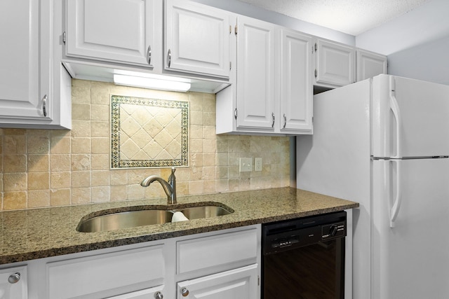 kitchen featuring black dishwasher, backsplash, white cabinets, sink, and dark stone counters