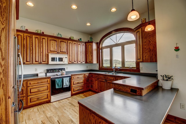 kitchen featuring dark countertops, white microwave, and pendant lighting