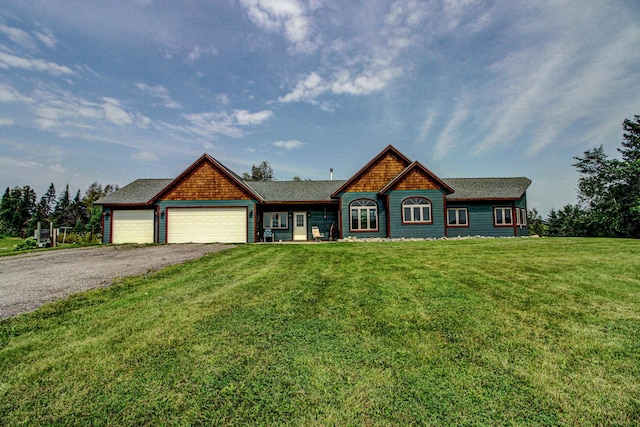 view of front of home with driveway, an attached garage, and a front yard