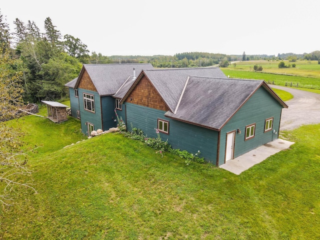 back of house with a garage, a yard, and driveway