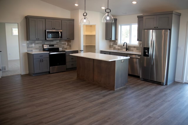 kitchen featuring appliances with stainless steel finishes, dark hardwood / wood-style flooring, lofted ceiling, and pendant lighting