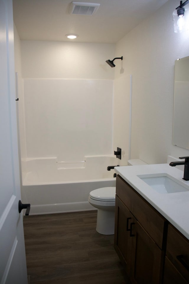 full bathroom featuring vanity, toilet, hardwood / wood-style flooring, and shower / washtub combination