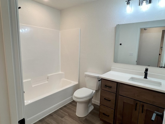 full bathroom with vanity, toilet, hardwood / wood-style flooring, and  shower combination