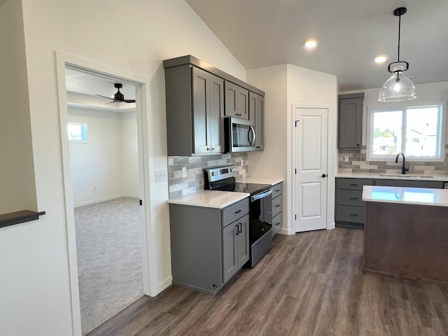 kitchen with gray cabinetry, stainless steel appliances, sink, and backsplash