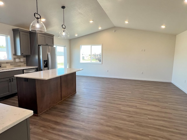 kitchen with lofted ceiling, stainless steel appliances, dark wood-type flooring, and a wealth of natural light