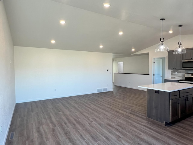 kitchen featuring a kitchen island, vaulted ceiling, dark wood-type flooring, pendant lighting, and stainless steel appliances