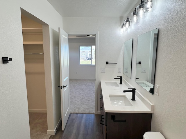 bathroom with vanity, wood-type flooring, a textured ceiling, and toilet