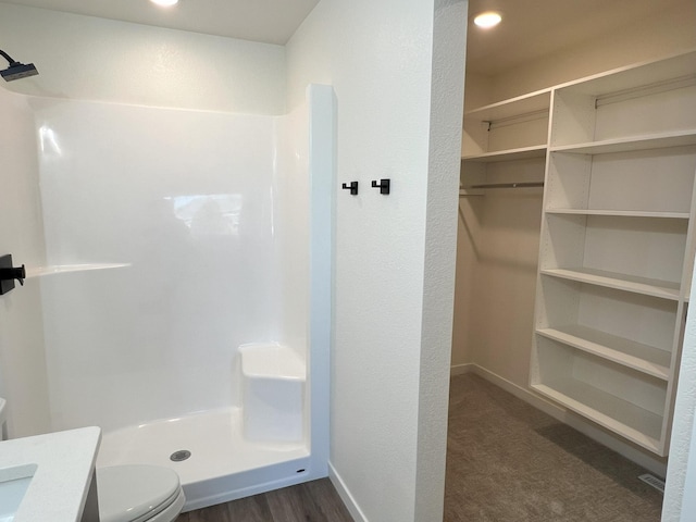 bathroom featuring vanity, toilet, walk in shower, and hardwood / wood-style floors