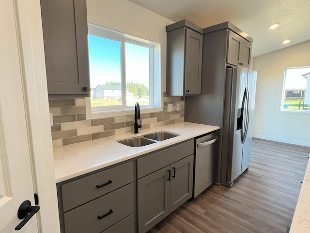 kitchen with gray cabinets, stainless steel appliances, and a healthy amount of sunlight