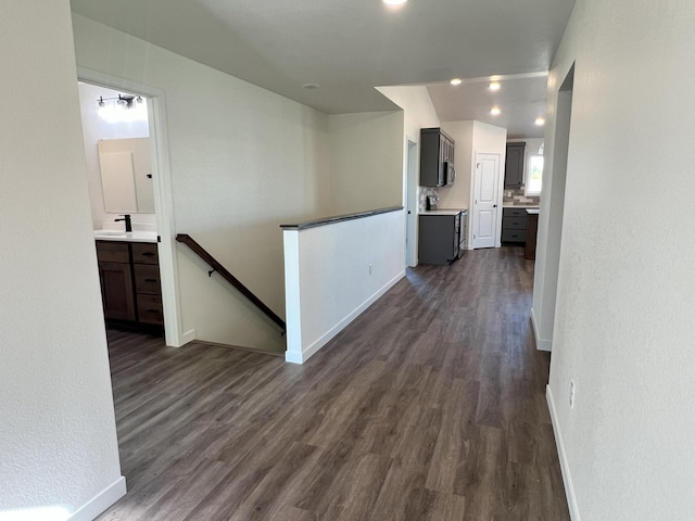 corridor featuring sink and dark wood-type flooring