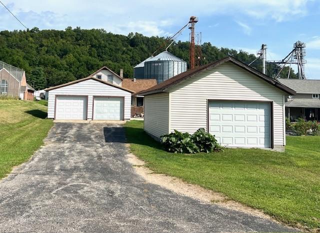 view of front of home featuring a front yard, an outdoor structure, and a garage