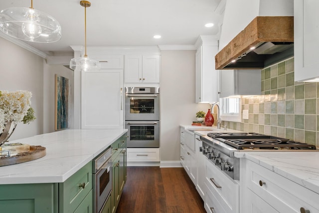 kitchen with custom exhaust hood, white cabinetry, green cabinets, decorative light fixtures, and stainless steel appliances