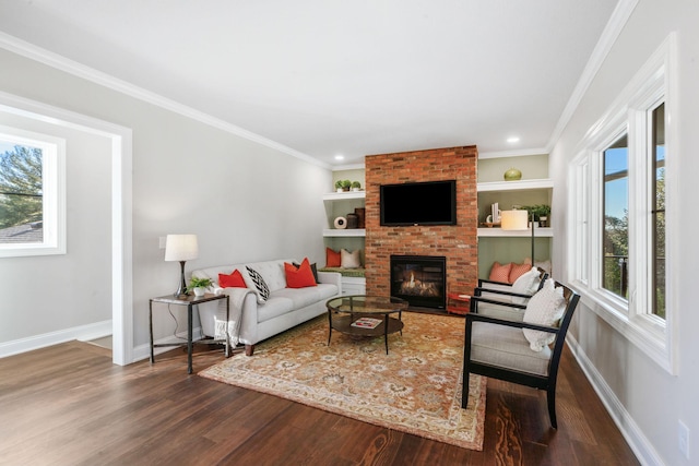 living room featuring a fireplace, built in features, hardwood / wood-style floors, and ornamental molding